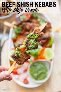 Um shish kebab de carne regado com mojo verde segurado pelo espeto