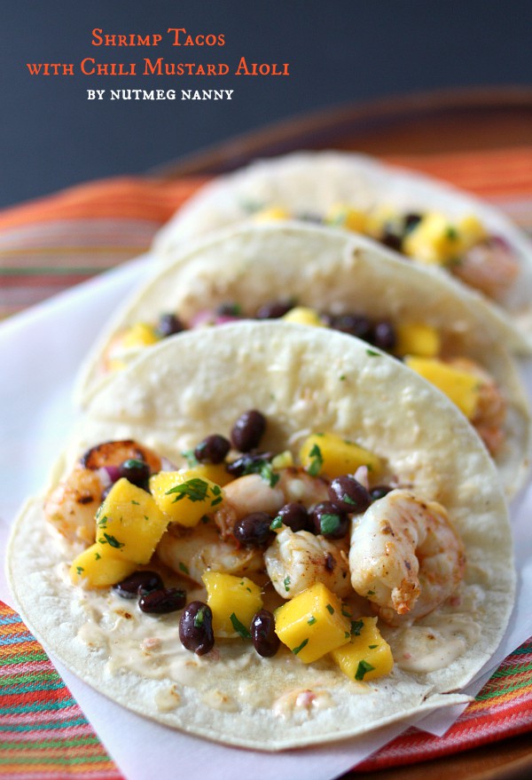 Estes tacos de camarão marinados em aioli de mostarda com pimenta são o taco perfeito para o verão. Embalado com sabor e coberto com manga doce e molho de feijão preto.