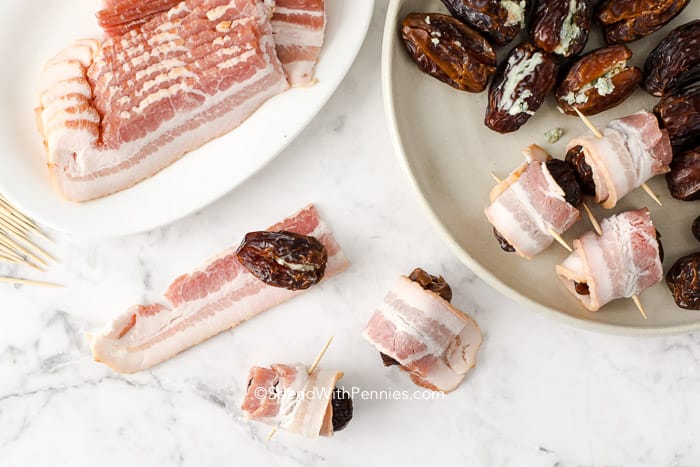 Bacon enrolado em datas sobre uma superfície de trabalho.