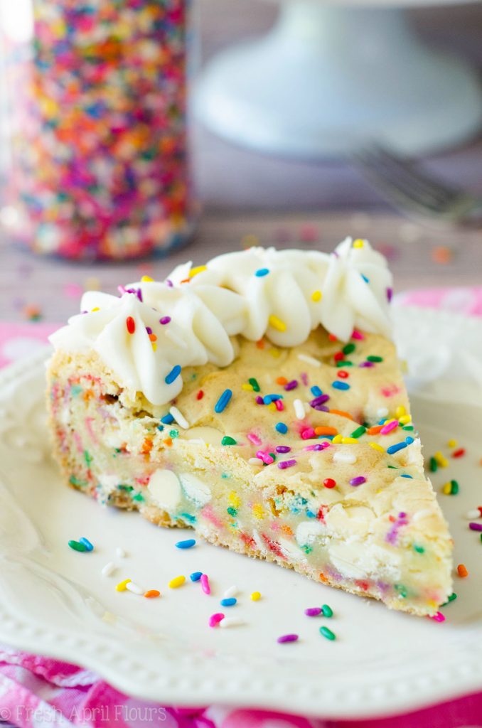 Bolo de biscoito de açúcar Funfetti: macio e amanteigado no centro, crocante nas bordas e cheio de gotas de chocolate branco e granulado para comemorar qualquer ocasião. Coberto com um creme amanteigado de manteiga de baunilha e amêndoa.