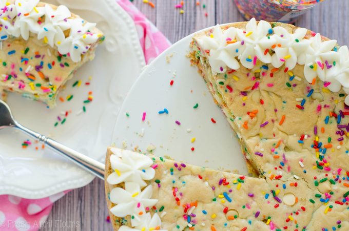 Bolo de biscoito de açúcar Funfetti: macio e amanteigado no centro, crocante nas bordas e cheio de gotas de chocolate branco e granulado para comemorar qualquer ocasião. Coberto com um creme amanteigado de manteiga de baunilha e amêndoa.
