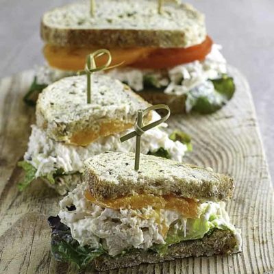 dois sanduíches de salada de frango no pão de trigo com tomate e alface