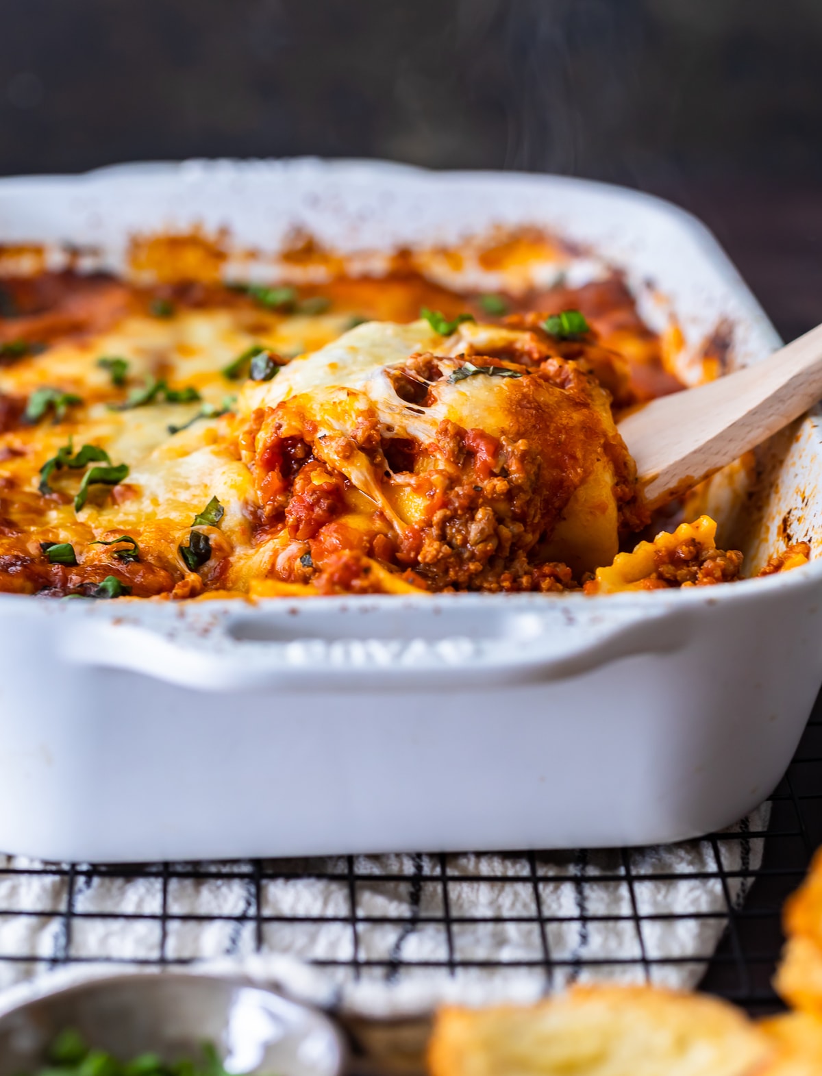 Ravioli Lasagna es una deliciosa mezcla de dos platos de pasta favoritos. Esta cazuela de ravioles con queso está hecha con capas de ravioles, salsa marinara mezclada con salchichas italianas y mucho queso. ¡Es una receta fácil de lasaña con una patada extra! A todos les encantará este horneado de lasaña de ravioles. lasaña de ravioles en una cacerola blanca