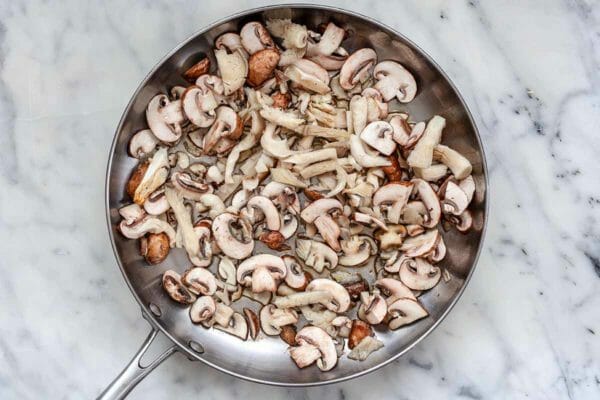 Como fazer Quesadillas vegetarianas - Frigideira de prata com cogumelos crus prestes a ser cozida