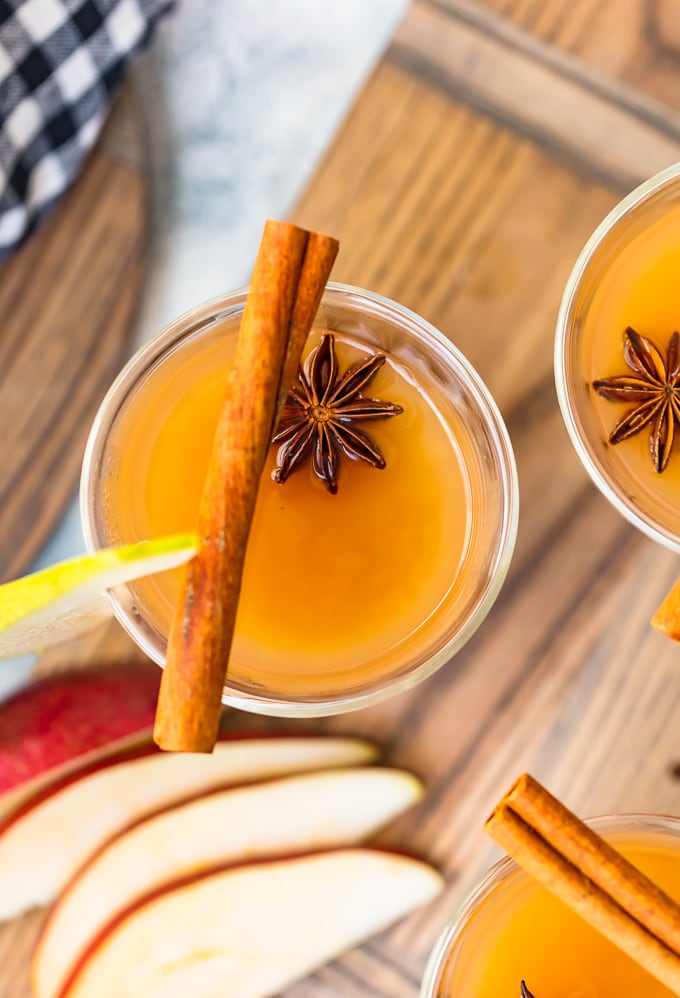 La sidra de pera es una bebida de otoño increíble. ¡Esta receta de Sidra de pera especiada es una mezcla de jugo de pera, sidra de manzana, licor de jengibre y muchas especias! Es una bebida alcohólica, pero también puedes hacer una versión sin alcohol. ¡Cálido, delicioso y perfecto para las vacaciones! Vista aérea de un vaso de sidra de pera, con anís y canela