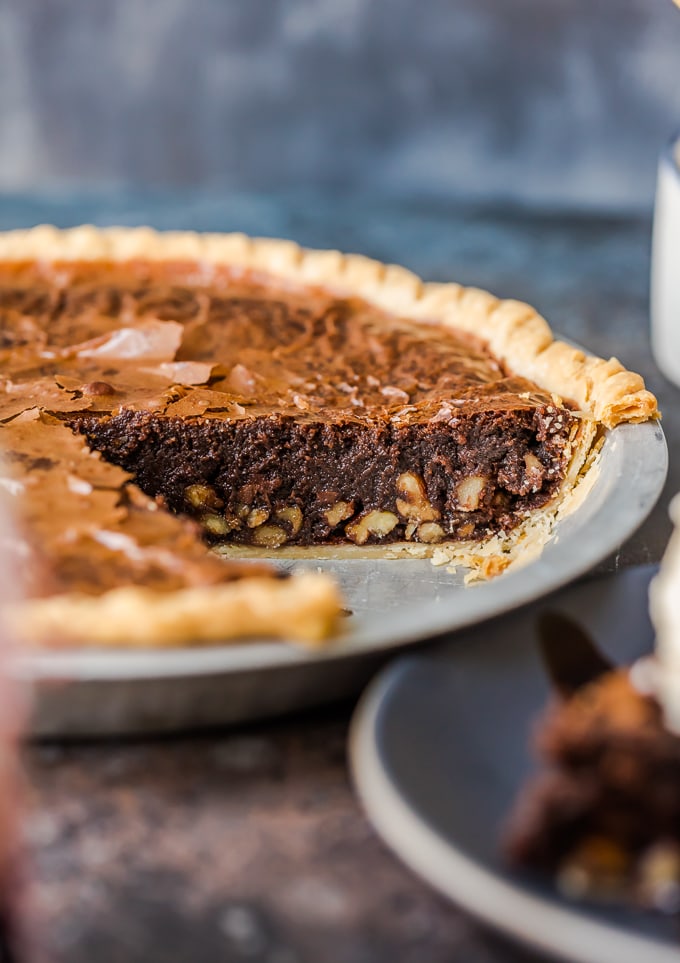 Brownie Pie es un rico postre de chocolate que es casi demasiado bueno para ser verdad. Una receta casera de brownie de chocolate horneado directamente en una masa de pastel te da dos postres en uno. Tarta de brownie con una capa de nueces adentro