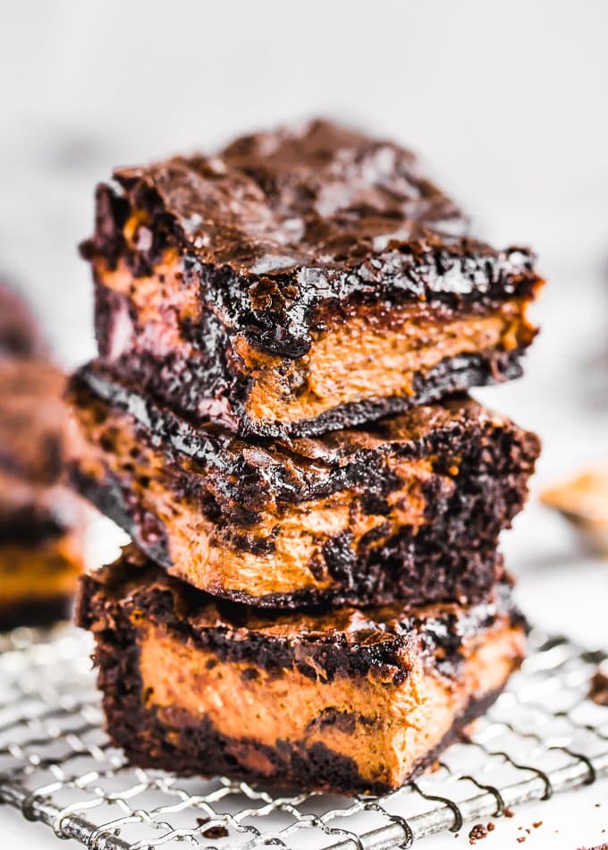 Brownies de abóbora são uma receita fácil de sobremesa de outono, perfeita para o Halloween ou o Dia de Ação de Graças. Adicione uma camada de abóbora aos seus brownies para algo divertido e delicioso! Uma pilha de brownies de abóbora