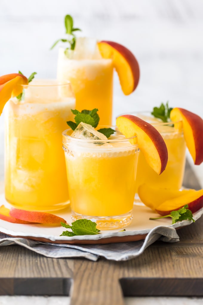 Limonada de pêssego é a nossa bebida de verão! Esta bebida fácil de pêssego é feita com apenas 2 ingredientes, ambos congelados, para que você possa fazer esta bebida gelada em minutos. Esta receita pode ser servida sem álcool para compartilhar com todos, ou você pode transformá-la em um delicioso coquetel de pêssego com um pouco de vodka. Esta bebida refrescante foi feita para o verão. Estou apaixonado!
