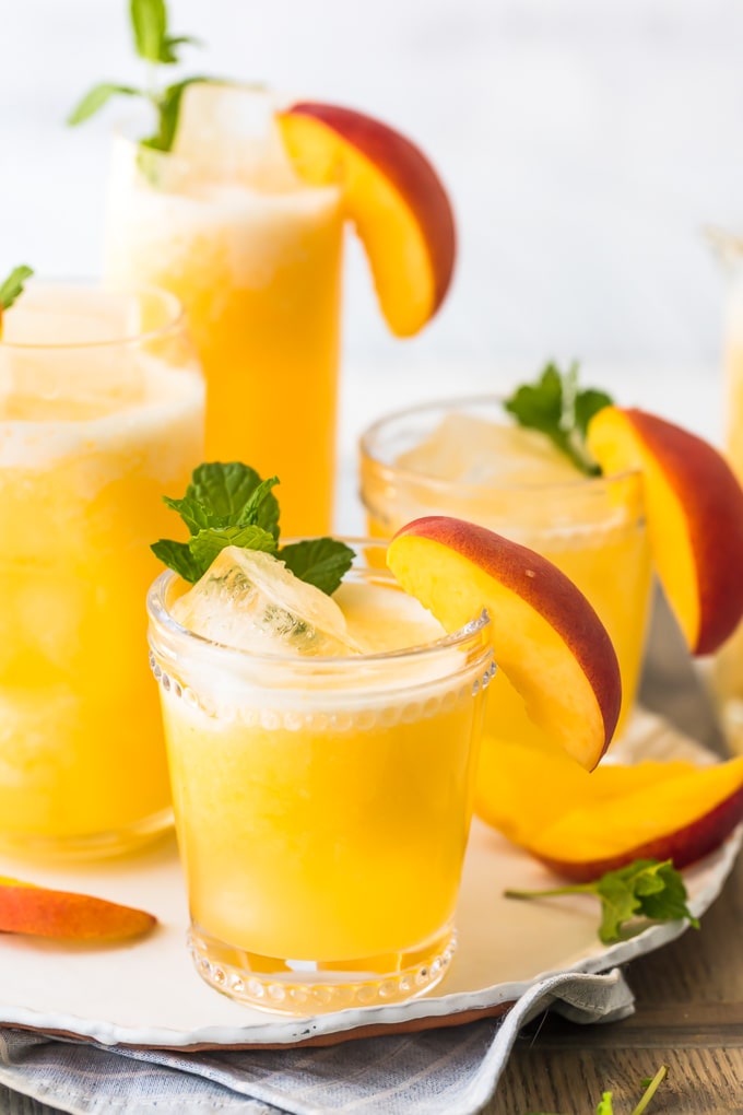 Limonada de pêssego é a nossa bebida de verão! Esta bebida fácil de pêssego é feita com apenas 2 ingredientes, ambos congelados, para que você possa fazer esta bebida gelada em minutos. Esta receita pode ser servida sem álcool para compartilhar com todos, ou você pode transformá-la em um delicioso coquetel de pêssego com um pouco de vodka. Esta bebida refrescante foi feita para o verão. Estou apaixonado!