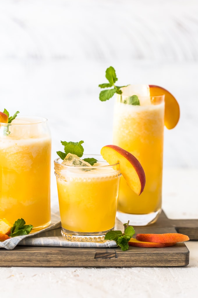 Limonada de pêssego é a nossa bebida de verão! Esta bebida fácil de pêssego é feita com apenas 2 ingredientes, ambos congelados, para que você possa fazer esta bebida gelada em minutos. Esta receita pode ser servida sem álcool para compartilhar com todos, ou você pode transformá-la em um delicioso coquetel de pêssego com um pouco de vodka. Esta bebida refrescante foi feita para o verão. Estou apaixonado!