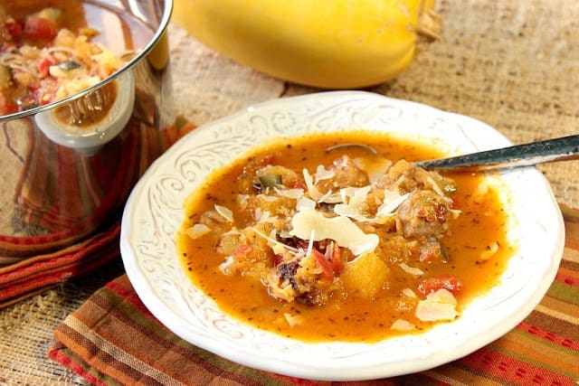 Bacia de sopa de polpa de espaguete com queijo parmesão barbeado e uma polpa de espaguete no fundo.
