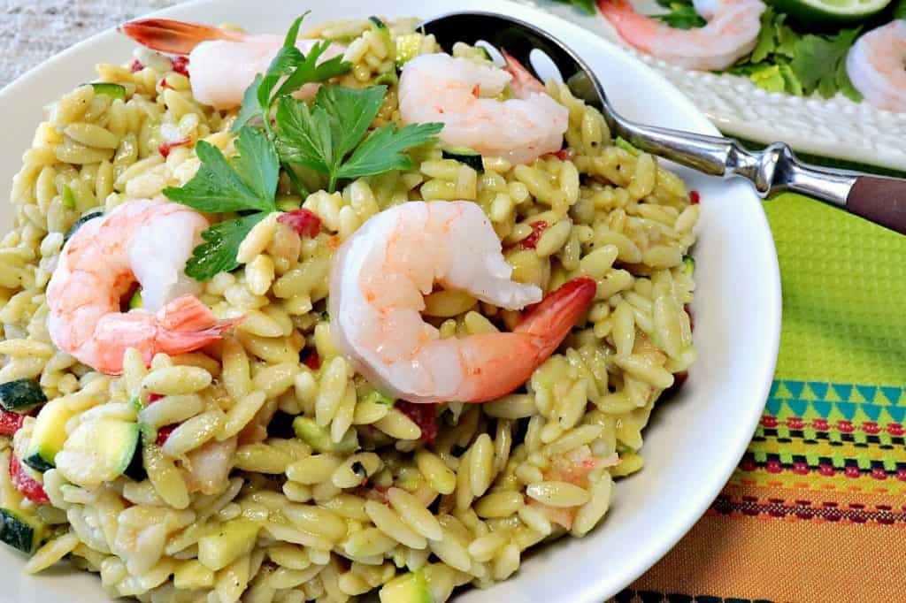 Orzo, salada de camarão e legumes com abacate recheado é um prato elegante que pode ser servido para uma refeição leve ou jantar. Uma vez que é servido frio, é o prato perfeito e refrescante para fazer e desfrutar durante os meses quentes do verão. - kudoskitchenbyrenee.com Salada de legumes recheada elegante de orzo, camarão e abacate. - www.kudoskitchenbyrenee.com