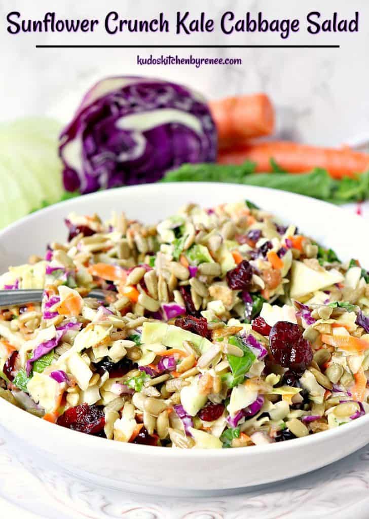 Bacia colorida de salada de repolho da couve com couve e as cenouras roxas no fundo.