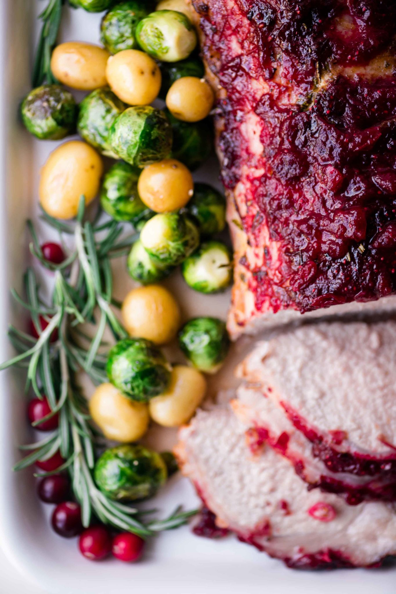 Carne de porco assada com cobertura de cranberry com batatas assadas e couve de Bruxelas