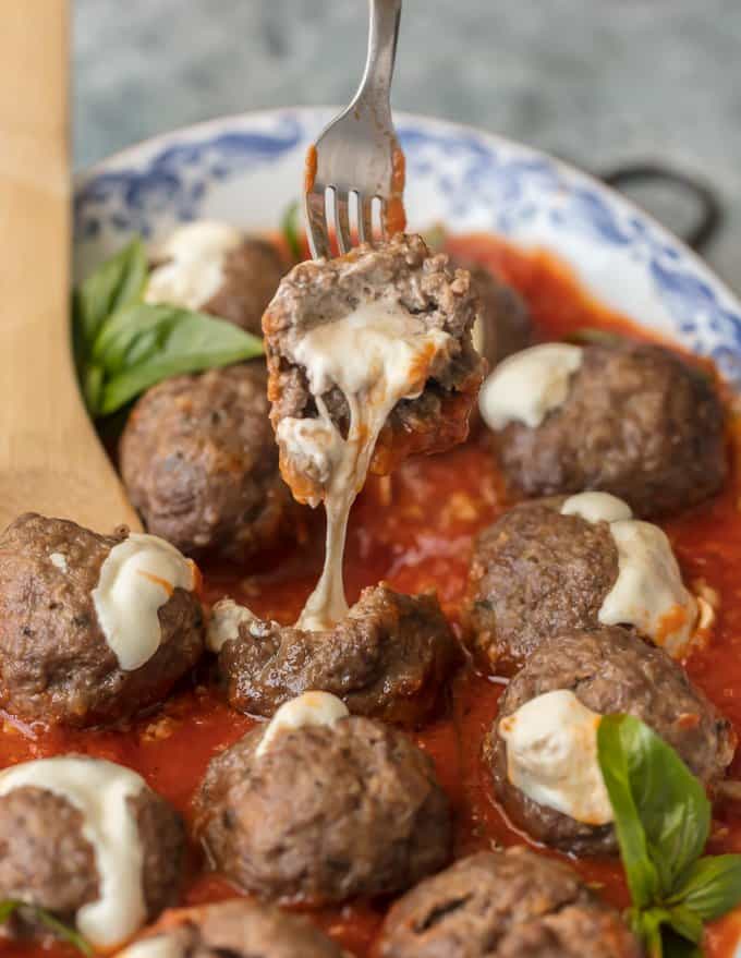 Albóndiga italiana en un tenedor con queso goteando