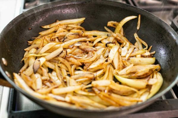 Caçarola de frango e arroz em fogo baixo cozinhe as cebolas até ficarem macias