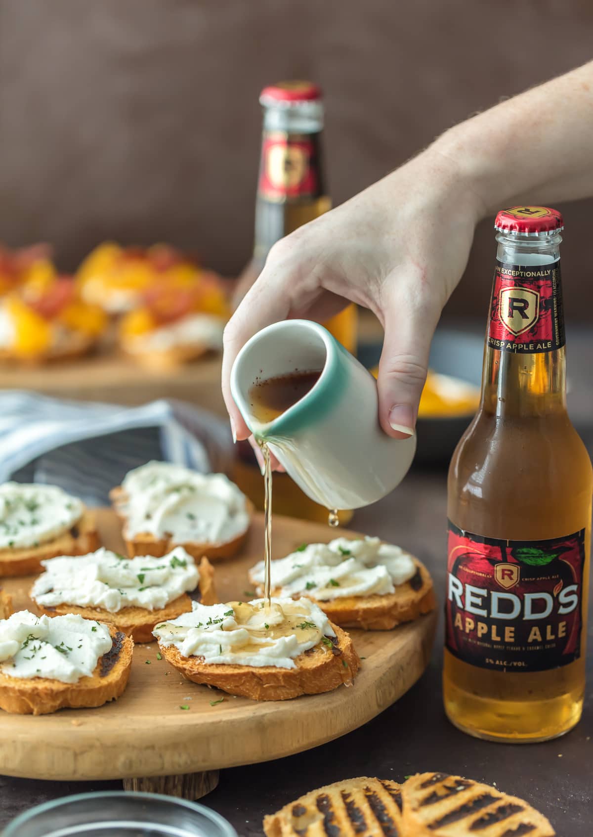Crostini de queijo de cabra em uma bandeja de madeira com duas maçãs de maçã vermelha