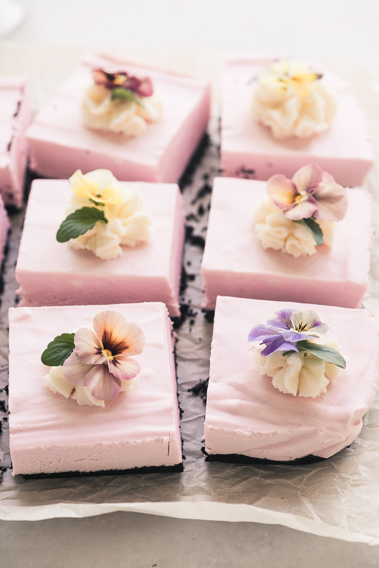 Cheesecake de morango cozido preto esquadra ~ Unbaked ~ The Perfect Spring Dessert! #receitas #receita #receita #receita #receita #receita #receita #receita #receita Quadrados de cheesecake com morangos e fundo preto cru, decorado com amores-perfeitos