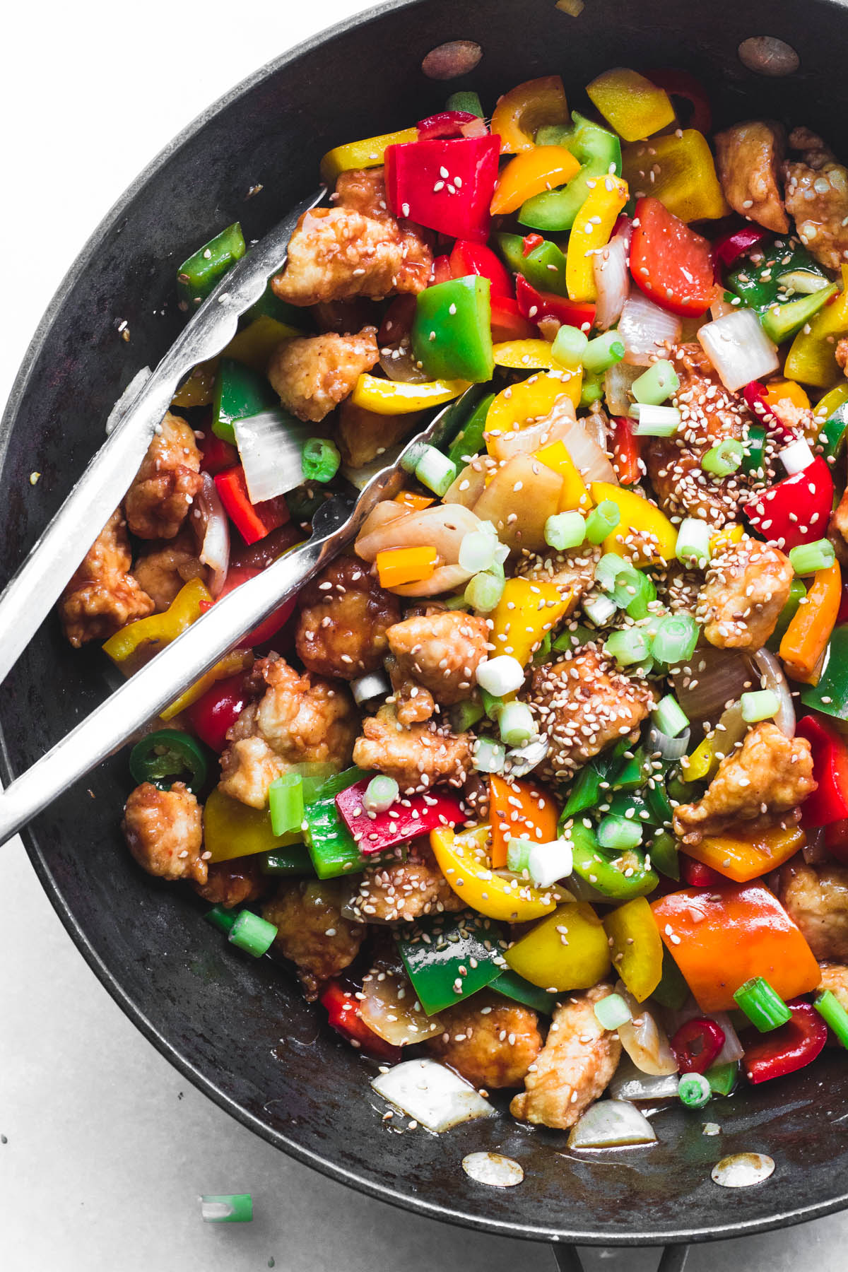 Fazendo frango fogos de artifício em uma wok com pinças