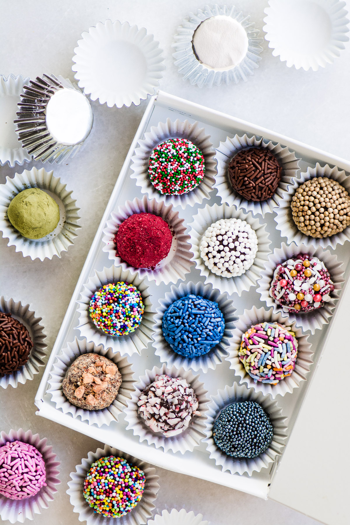 Trufas de caixa de jóias ~ Eu desafio você a encontrar um alimento festivo mais fácil do que esses bombons deslumbrantes. Se você pode derreter o chocolate, você pode fazê-lo! #recipe #comida #ganache #christmas #comida # doces # chocolates #sprinkles #nobake #decoration #dessert Trufas de caixa de jóia em uma caixa branca