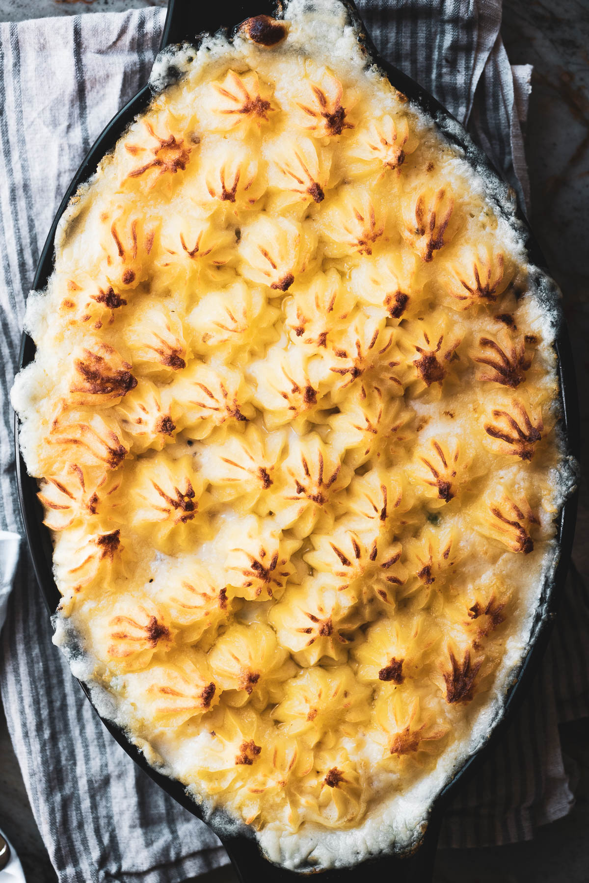 Uma torta de peixe coberta com purê de batatas, fresca do forno