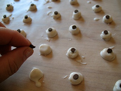 Coloque uma mini lasca de chocolate, com a face para baixo, no centro de cada Cheerio envidraçada