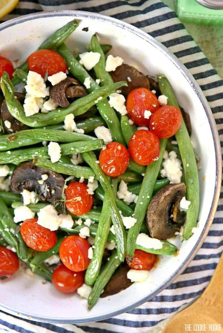 Feijão verde assado com queijo feta e tomate é brilhante, delicioso e saudável! O enfeite fácil e perfeito para qualquer jantar. Feito de forma rápida e fácil!