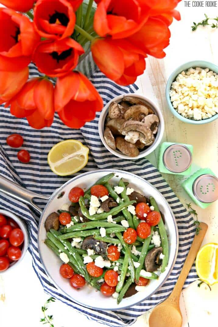 Feijão verde assado com queijo feta e tomate é brilhante, delicioso e saudável! O enfeite fácil e perfeito para qualquer jantar. Feito de forma rápida e fácil!