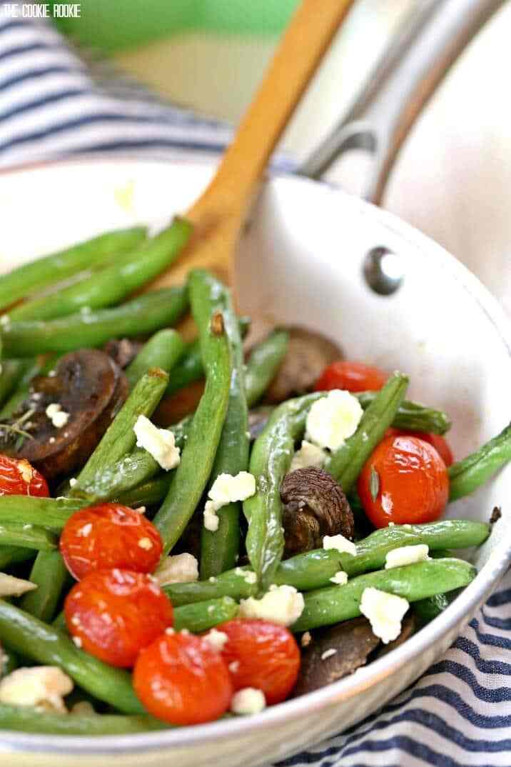 Feijão verde assado com queijo feta e tomate é brilhante, delicioso e saudável! O enfeite fácil e perfeito para qualquer jantar. Feito de forma rápida e fácil!
