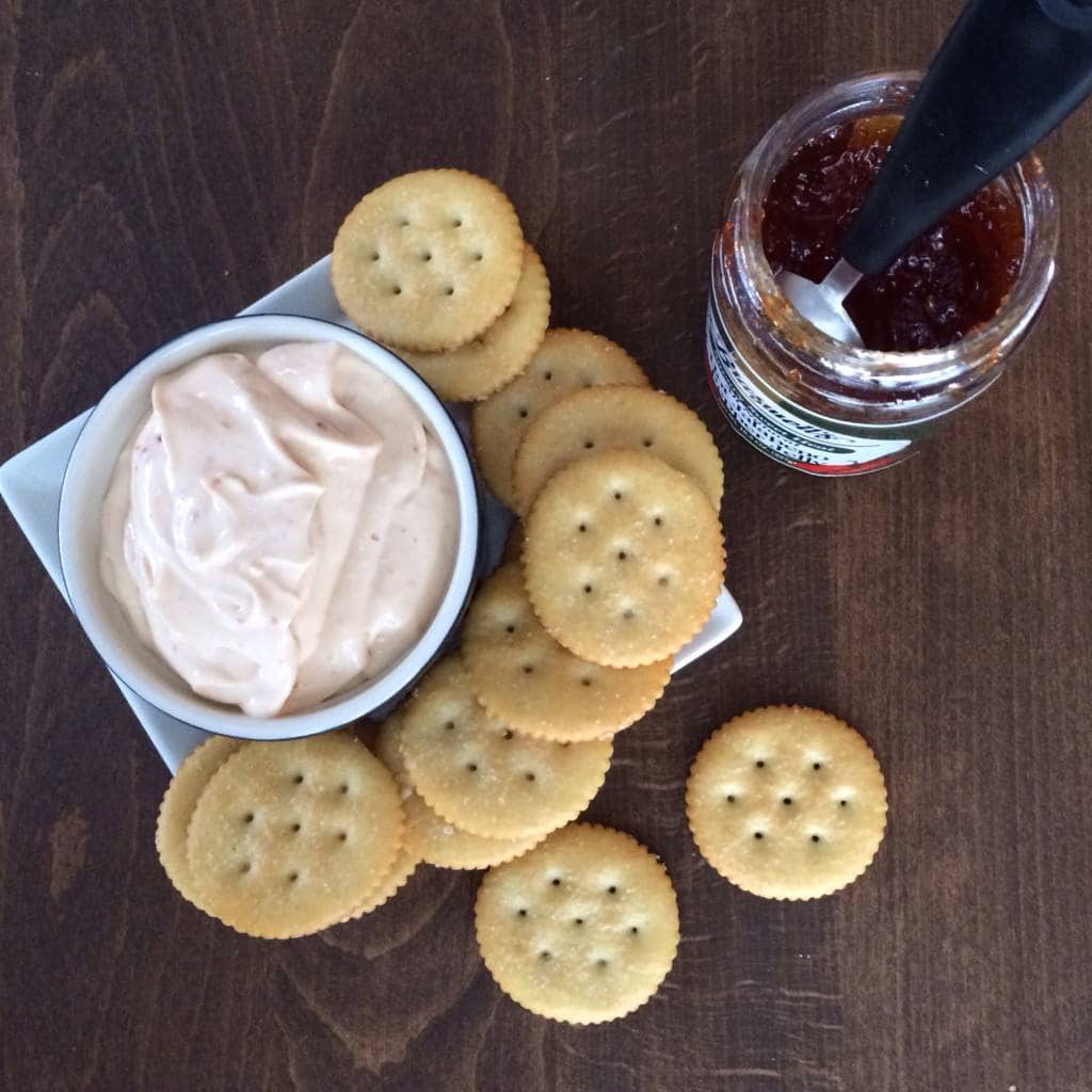 molho de queijo creme de gelatina de pimenta em uma tigela cercada por biscoitos