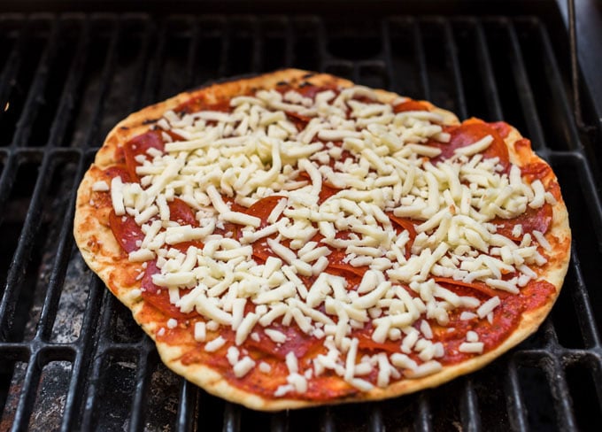 pizza cozinhando em uma churrasqueira a gás