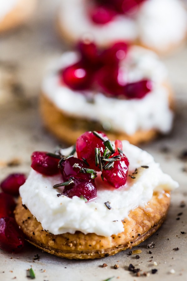 Essas belíssimas mordidas de romã com queijo de cabra são feitas em menos de 30 minutos e são o lanche perfeito e perfeito para as férias. A massa de torta comprada na loja é cortada e assada em pequenos pedaços de bolachas e coberta com queijo de cabra batido com mel, sementes de romã e uma pitada de mel e alecrim. Você vai adorar este novo lanche rápido e fácil! 