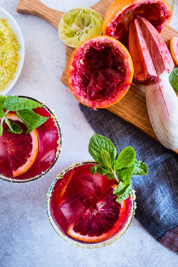 Esta margarita de laranja e gengibre é o coquetel perfeito para as suas festas de fim de semana! Este bebê usa laranjas sanguíneas e as combina com gengibre quente, suco de limão, tequila e xarope de agave. Você vai adorar o quão fácil é fazer esses coquetéis frescos e sazonais!