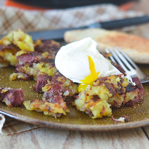 Hash de carne enlatada coberto com ovo escalfado 