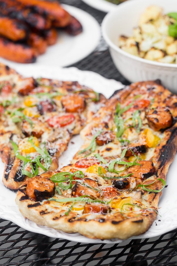 Esta pizza de salsicha de frango grelhado é 100% grelhada e perfeita para animar sua rotina normal de churrasco. Coberto com lingüiça de frango grelhado, cogumelos, tomate cereja, queijo mussarela e bastante manjericão fresco. Você quer fazer parte do seu verão o mais rápido possível!
