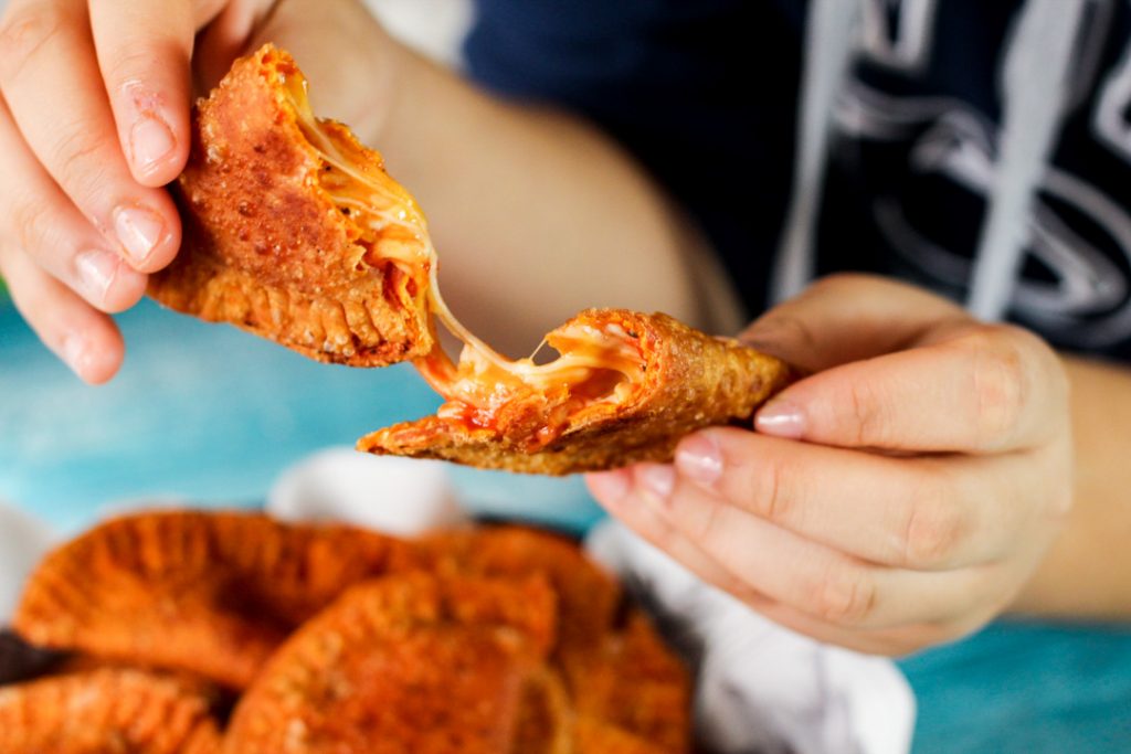 Queijo pegajoso no centro de uma empanada de pizza