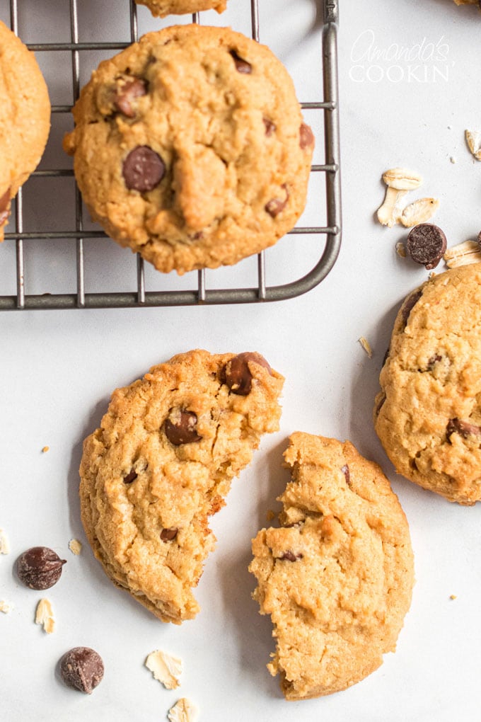 La cremosa mantequilla de maní y la avena masticable se unen para hacer deliciosas galletas de chispas de chocolate con avena y mantequilla de maní. ¡La gente preguntará por esta receta! galleta rota cerca del estante de enfriamiento
