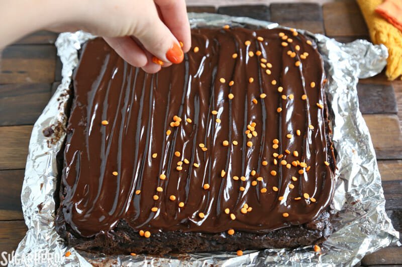 Brownies de Abóbora com 2 Ingredientes - Adicionando Granulado de Laranja Sobre a Cobertura de Chocolate Espumante | From SugarHero.com