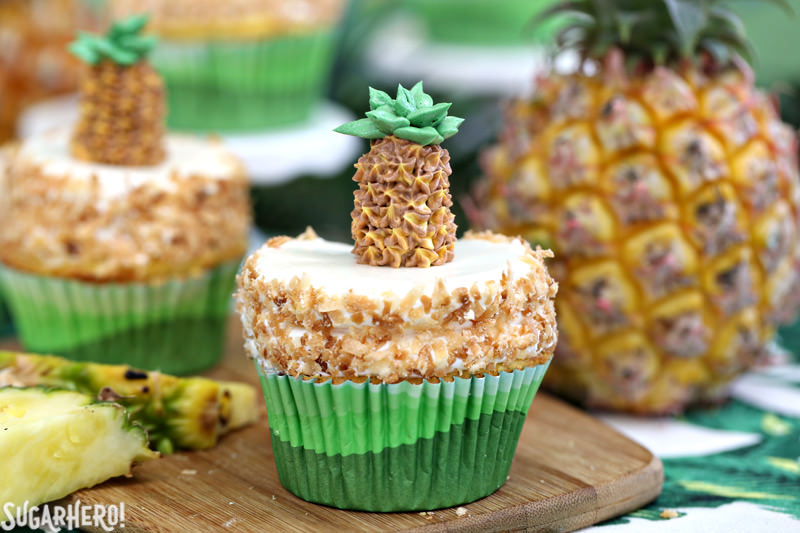 Dois muffins de abacaxi com creme de coco e pedaços de abacaxi fresco | From SugarHero.com