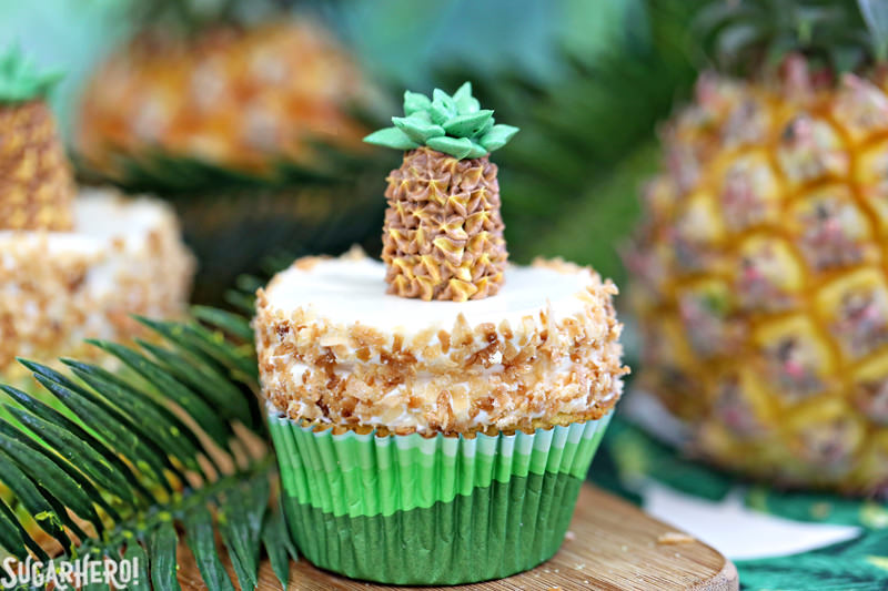 Cupcakes de abacaxi: Cupcakes divertidos e tropicais de abacaxi com cobertura de coco. Além de um adorável abacaxi com creme de manteiga por cima. O | From SugarHero.com