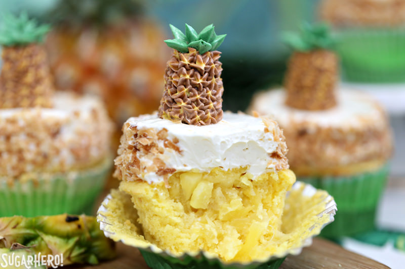 Cupcake de abacaxi com creme de coco e abacaxi fresco derramado fora do centro | From SugarHero.com