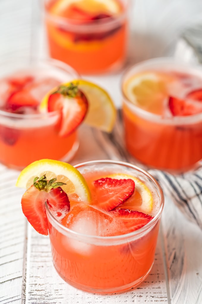 4 vasos cortos llenos de ponche de limonada de fresa