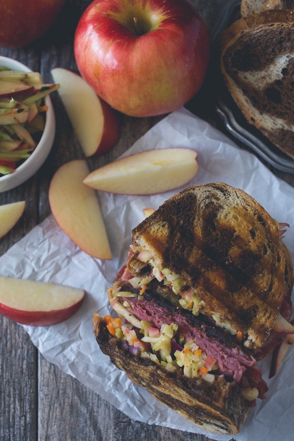 Este repolho picante de maçã em conserva é o sanduíche perfeito para o outono. Centeio de mármore perfeitamente torrado coberto com uma salada de repolho de maçã, carne enlatada, queijo suíço derretido e muitos temperos russos caseiros.