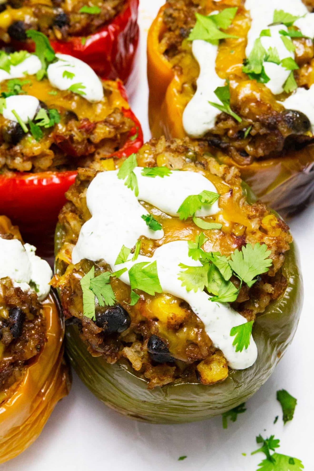 Esses pimentos recheados com cozimento lento, tex-mex, dão um toque especial à receita original dos pimentos recheados. Eles são feitos no fogão lento e cobertos com um creme azedo de coentro incrível para completar esta refeição deliciosa e fácil!