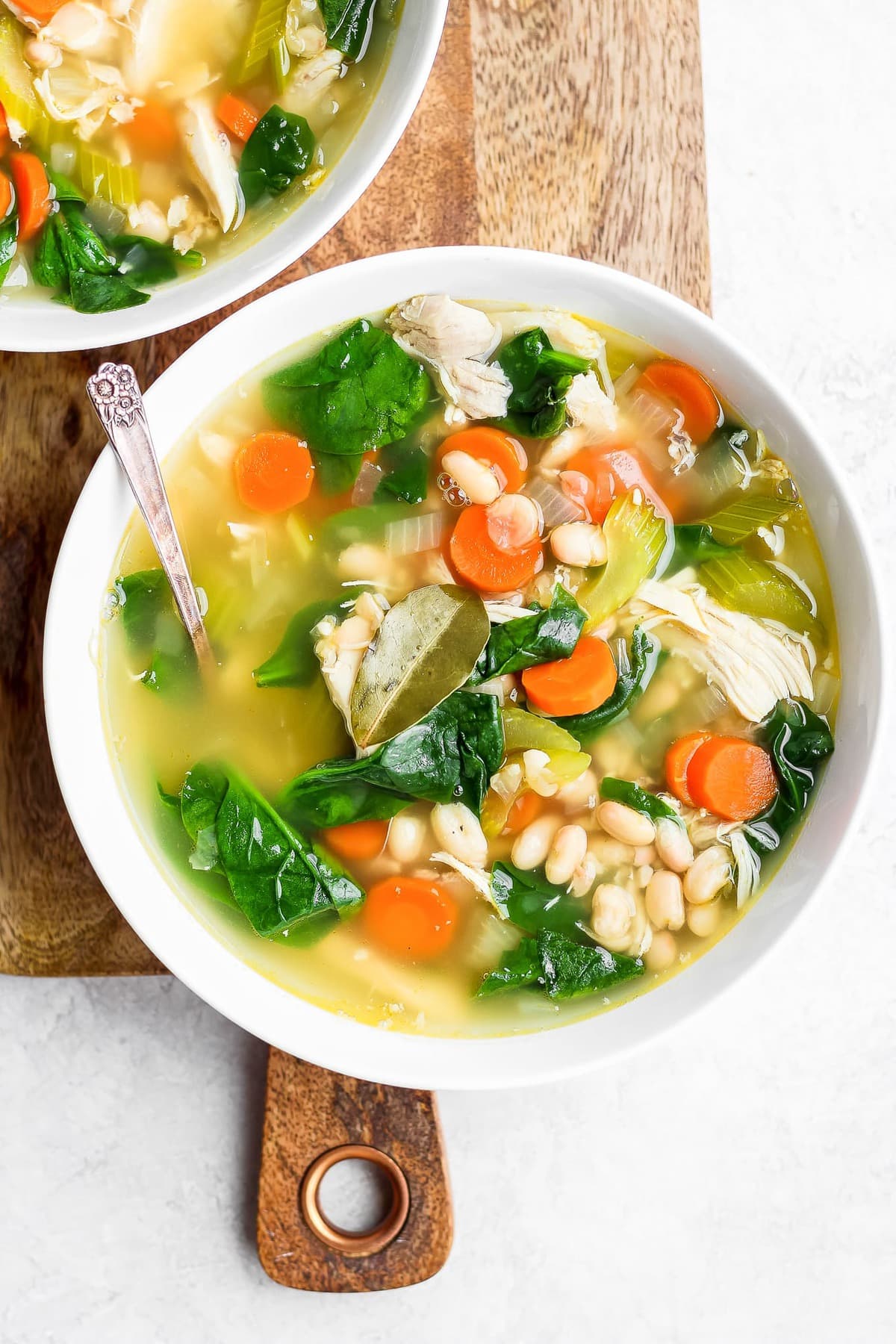 tigela de sopa cheia de frango, cenoura, feijão e muito mais