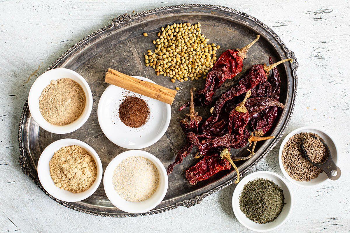 Uma travessa grande com vários pimentos e especiarias em pratos brancos.