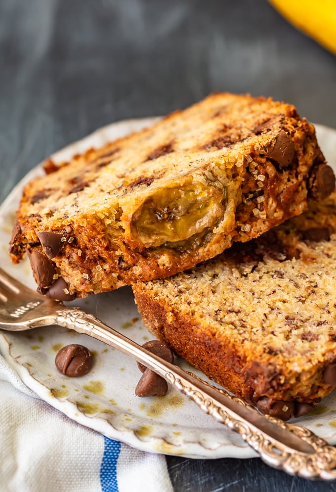 Dos rebanadas de pan de plátano con chispas de chocolate en un plato blanco