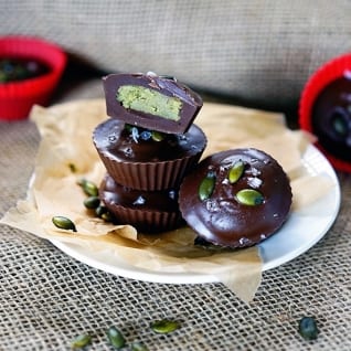 Tazas oscuras de la mantequilla de la semilla de calabaza del chocolat