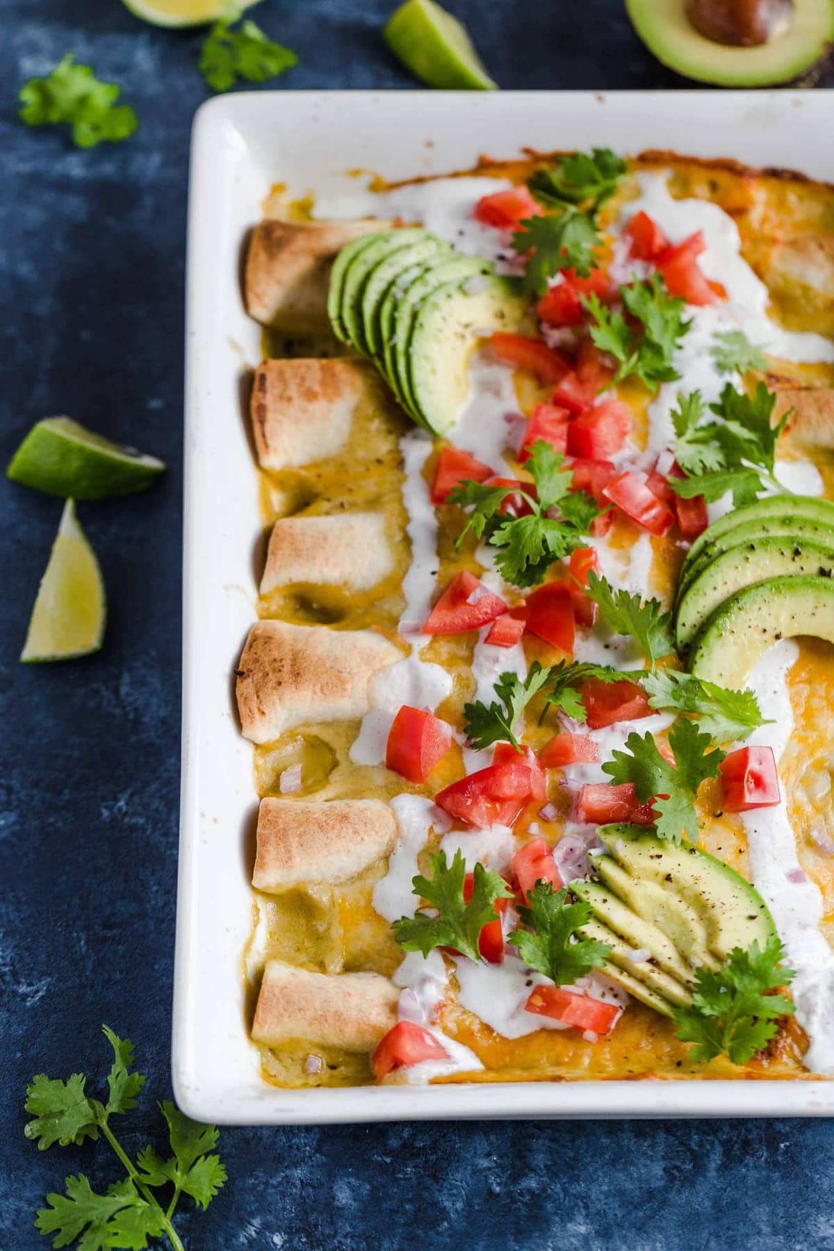 Enchiladas de pollo con lima y miel cubiertas con tomates, aguacate, crema agria y cilantro