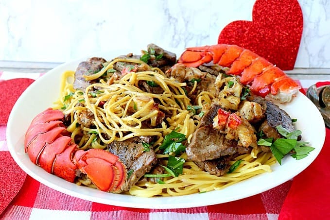 Linguine de bistec y langosta sobre un mantel a cuadros rojo y blanco. - Kudos Kitchen de Renee